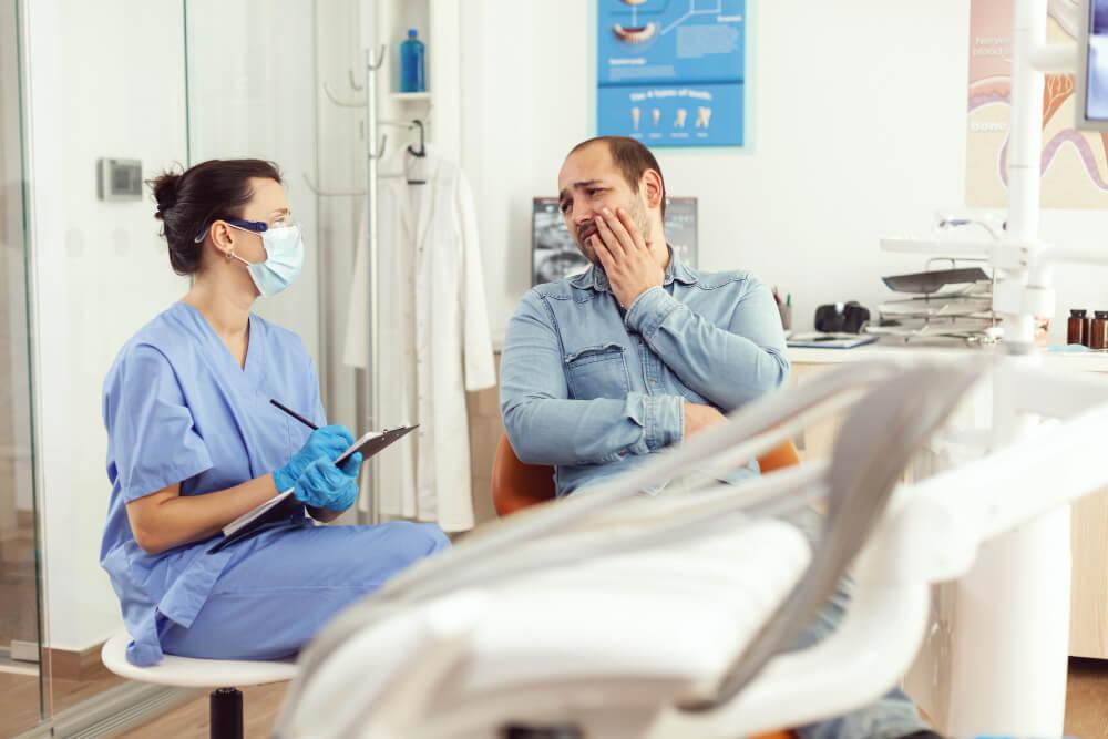 a dentist talking to a man with a toothache