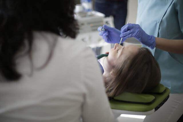 a woman laying on the dentist chair while receiving dental care