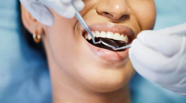A dentist examining a patient's cold sensitive teeth during a routine checkup.