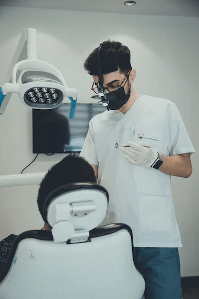 a dentist performing teeth cleaning on his patient